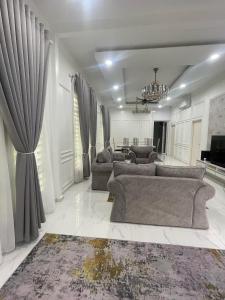 コタバルにあるQaseh homestayのソファのあるリビングルームとダイニングルーム