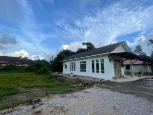 コタバルにあるQaseh homestayの窓が多い白い家