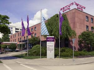 a building with purple and white flags in front of it at Mercure Hotel München Süd Messe in Munich