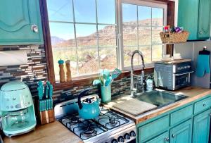 a kitchen with a stove and a sink and a window at The Ark Tiny House near Zion National Park, Utah in Virgin