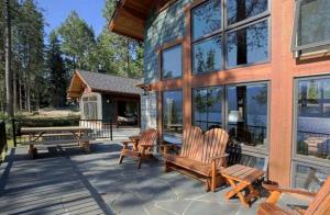 a patio with two wooden chairs and a building at Lakeside Vacation Rental with Stunning Views and Spacious Interior on Flathead Lake, Montana in Finley Point
