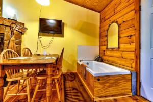 ein Bad mit einer Badewanne, einem Tisch und Stühlen in der Unterkunft Cozy Creekside Cabin Rental near Cherokee, North Carolina in Cherokee