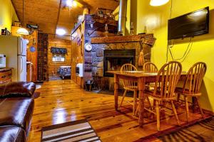 ein Wohnzimmer mit einem Holztisch und einem Kamin in der Unterkunft Cozy Creekside Cabin Rental near Cherokee, North Carolina in Cherokee