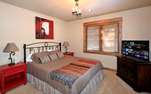 a bedroom with a bed and a flat screen tv at Family-Friendly Cabin Rental with Lone Peak Views in Big Sky in Big Sky Mountain Village