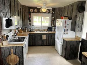 une cuisine avec des armoires en bois et un réfrigérateur blanc dans l'établissement Stunning Cottage with Fire Pit in Saratoga, Wyoming, à Encampment