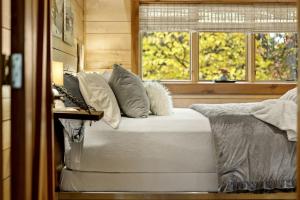 une chambre avec un lit avec des oreillers et une fenêtre dans l'établissement Impressive Log Cabin with Fireplace, Fire Pit and Hot-tub in Unionville, Indiana, à Unionville