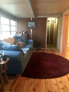 une personne assise sur un canapé dans un salon dans l'établissement Forested Wood Cabin near Ocala National Forest in Central Florida, à Fort McCoy