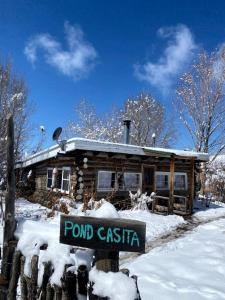 Το Log Casita Overlooking Pond and Waterfall near Taos, New Mexico τον χειμώνα