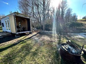 a tiny house in the grass next to a field at Friendsville Renovated Container Rental, for True Glamping Experiences in Maryland in Friendsville