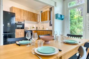 a kitchen and dining room with a wooden table and chairs at Barthélémy cozy house in the city center in Rouen