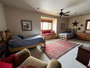 a bedroom with two beds and a couch at Scenic Creekside Lodge with Decks and Madison River Access near Yellowstone, Ennis Montana in Grahams Place