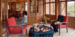 a living room with two chairs and a table and a dining room at Scenic Creekside Lodge with Decks and Madison River Access near Yellowstone, Ennis Montana in Grahams Place