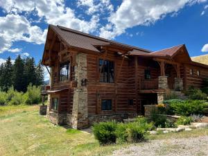 Grahams PlaceにあるScenic Creekside Lodge with Decks and Madison River Access near Yellowstone, Ennis Montanaの野原にある丸太小屋