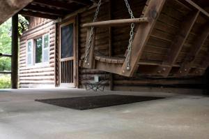 an empty porch with a swing in a cabin at Pet-Friendly Cabin Retreat in the Ozarks of Scenic Newton County, Arkansas in The Basin