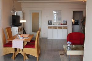 a living room with a dining room table and a kitchen at Ferienappartements Marina Wendtorf an der Ostsee in Wendtorf