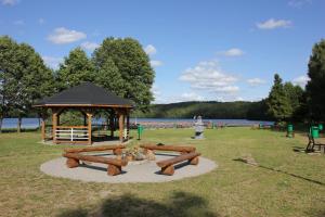 a park with a gazebo next to a lake at Domek nad jeziorem 7 in Kamienica Królewska