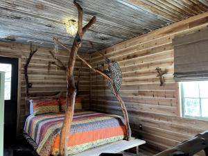 Кровать или кровати в номере Magical Treehouse with Slide by Brazos River for Family Glamping Adventures in Texas