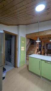 a room with a kitchen with a staircase in the background at Cantiño 39 in Lugo