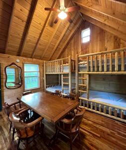 a dining room with a table and two bunk beds at Secluded Riverside Cabin for 8 in Belfast, NY with Rustic Amish-Built Retreat in Oramel