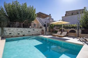 a swimming pool with two chairs and an umbrella at Captain's Hyatt in Garazo