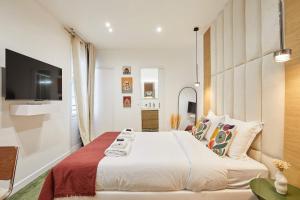 パリにあるLuxury Suite in the Center of Parisの大きなベッドとテレビのある寝室