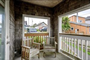 - une terrasse couverte avec 2 chaises et une fenêtre dans l'établissement Incredible Beach House with Stunning Views in Newport, Oregon, à Newport