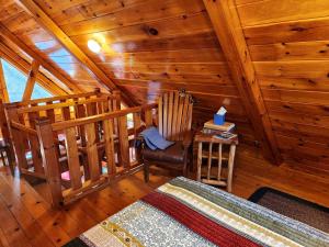 a room with a chair and a table in a cabin at Charming Creekside Log Cabin with Wood Burning Stove Overlooking the Neshannock Creek, Western PA in Volant
