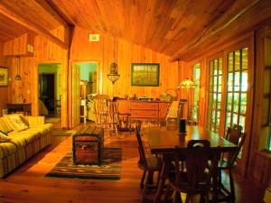 a living room with a table and a dining room at Rustic Cabin on a Ranch near the Ocala National Forest in Central Florida in Fort McCoy