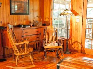 a room with two wooden chairs and a desk at Rustic Cabin on a Ranch near the Ocala National Forest in Central Florida in Fort McCoy