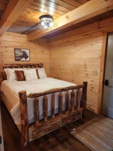 a bedroom with a bed in a log cabin at Group Friendly Cabin with Spa on the Deck in Ohio in Deersville
