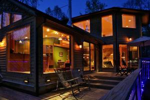 a house with two chairs and an umbrella on a deck at Luxury Mountain Cabin Rental on Rockfish Gap River near Charlottesville, Virginia in Wintergreen