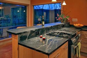 a kitchen with a granite counter top with a stove at Luxury Mountain Cabin Rental on Rockfish Gap River near Charlottesville, Virginia in Wintergreen
