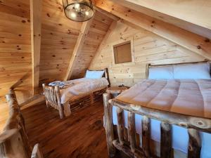 a bedroom with two beds in a log cabin at Group Friendly Cabin with Spa on the Deck near Tappan Lake in Ohio in Deersville
