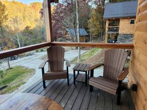 a porch with two chairs and a table and a window at Group Friendly Cabin with Spa on the Deck near Tappan Lake in Ohio in Deersville +38 photos