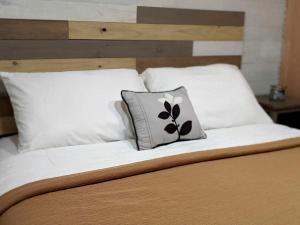 a bed with a pillow with a flower on it at Tiny House with Amazing Views and Private Hiking Trails in Hill Country, Texas in Freedom Springs Ranch Airport