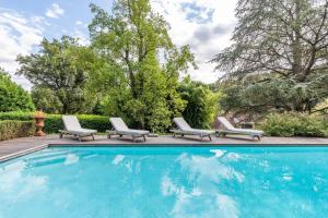 una piscina con due sdraio e due sedie accanto di Le Pressoir - Newly refurbished house with contemporary decoration a Saint-Cyr-au-Mont-dʼOr