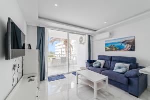 a living room with a blue couch and a table at Costa Dreams Costa Adeje in Costa de Adeje