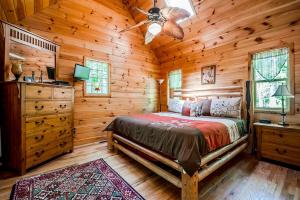 a bedroom with a bed in a wooden cabin at Gorgeous Cabin with Pool Table, Fire Pit and Hot-tub in Cleveland, Georgia in Kinseytown