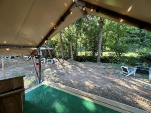 Tienda de campaña con mesa y sillas en un patio en Exquisite Safari Tent Haven near Smoky Mountains in Tennessee, en Parrottsville