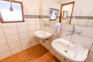 a white bathroom with a sink and a mirror at Cozy Cabin in Triglav National Park for Family Getaways in Slovenia in Soča