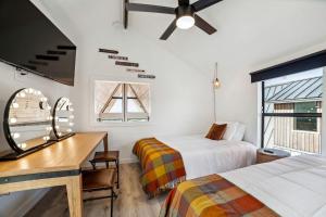 Un dormitorio con dos camas y un escritorio y una ventana. en Elegant Modern A-Frame Surrounded by Nature in Texas, en Fourth Crossing