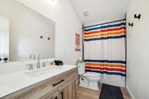 Un baño con lavabo, inodoro y cortina de ducha. en Elegant Modern A-Frame Surrounded by Nature in Texas, en Fourth Crossing