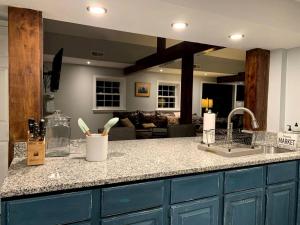 un bancone cucina con lavandino e un soggiorno di Sweet Chic Farm Cottage with Pool, Hot-Tub and Beautiful Sunsets in Maryland a Seneca Highlands Altre 28 foto