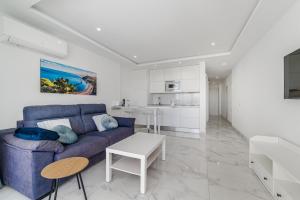 a living room with a blue couch and a table at Costa Dreams Costa Adeje in Costa de Adeje