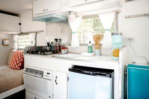 eine Küche in einem Wohnwagen mit einer Spüle und einem Herd in der Unterkunft Dream Glamping at Adult-Only Vintage Camper Destination in Franklin, North Carolina in Franklin