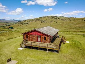a cabin in the middle of a grassy field at Secluded Cabin Rental for a Peaceful Vacation in Montana in Pony
