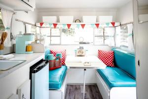 eine Küche mit einem Tisch und einer Bank in einem Wohnwagen in der Unterkunft Dream Glamping at Adult-Only Vintage Camper Destination in Franklin, North Carolina in Franklin + 32 Fotos