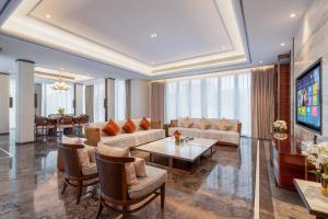 a living room with a couch and a table at Sanya Haitang Bay Renguan Sea View Pool Villa (Water World Duty Free City Store) in Sanya