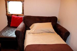 a brown leather couch with a pillow on it at Glamping Caboose Rental Perfect for Families near Clyde, North Carolina in Crabtree +3 photos