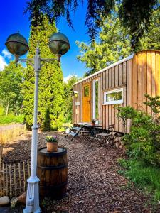 a wooden cabin with a street light next to a barrel at Wonderful Tiny House Perfect for a Unique Glamping Experience in Germany in Vorpochten